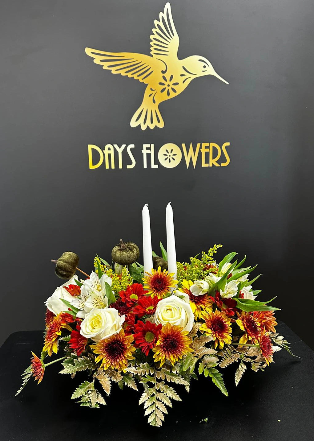 Days Flowers Florida: Autumn floral arrangement with white roses and two candles. Symbolizes gratitude and joy. Thanksgiving delivery in Ocala, FL