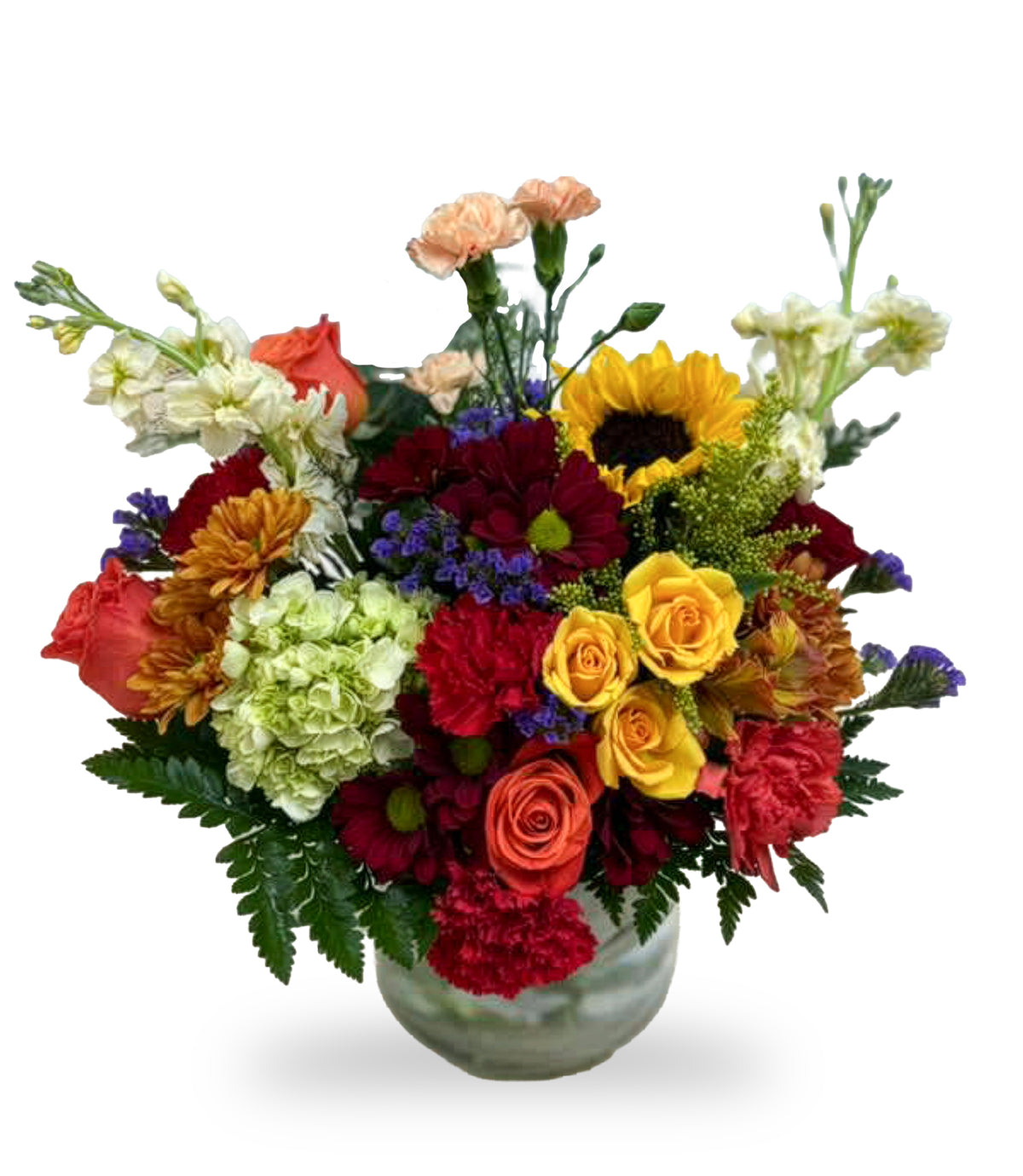 Autumn Sunset & Sunflower Splash arrangement by Days Flowers Florida, featuring a yellow sunflower, orange roses, red carnations, and a green hydrangea in a clear glass bubble vase