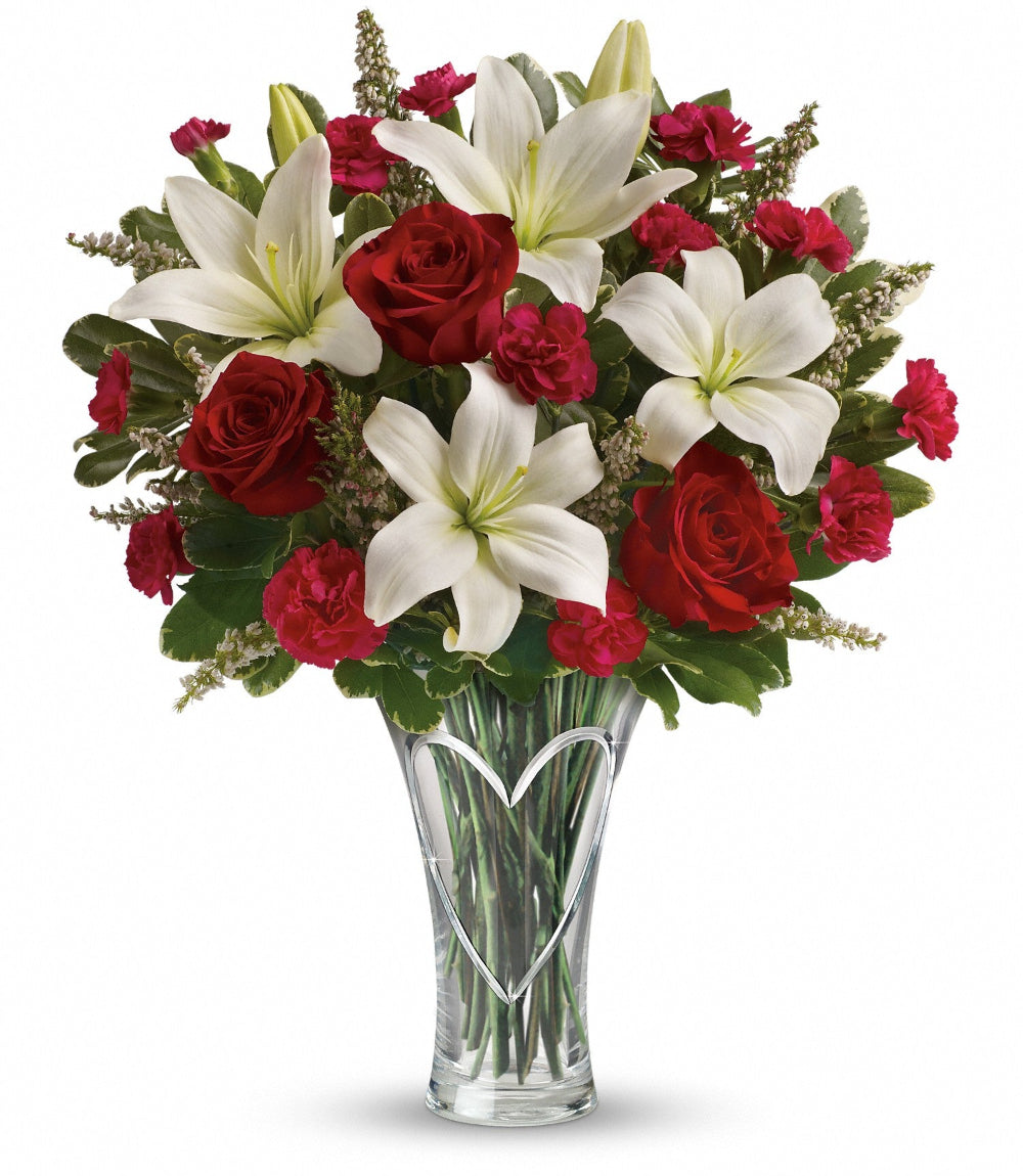 Heartfelt Bouquet featuring red roses, snow-white asiatic lilies, and hot pink mini carnations in a hand-cut heart glass vase by Days Flowers Florida