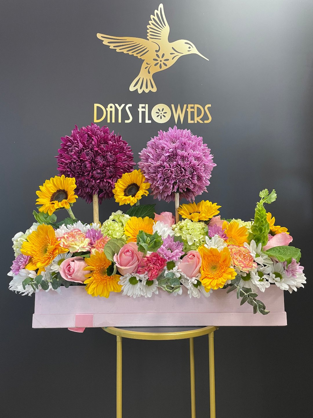 Vibrant floral arrangement with sunflowers, pink roses, and purple blooms, perfect gift for free delivery in Florida areas.