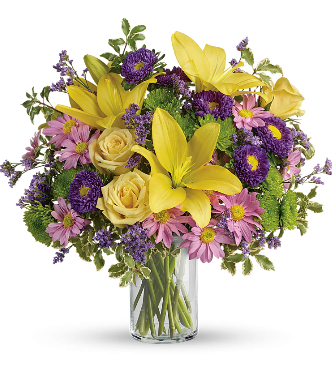 Bright yellow lilies and roses with pink blooms in a glass vase, perfect for free delivery in Florida areas.