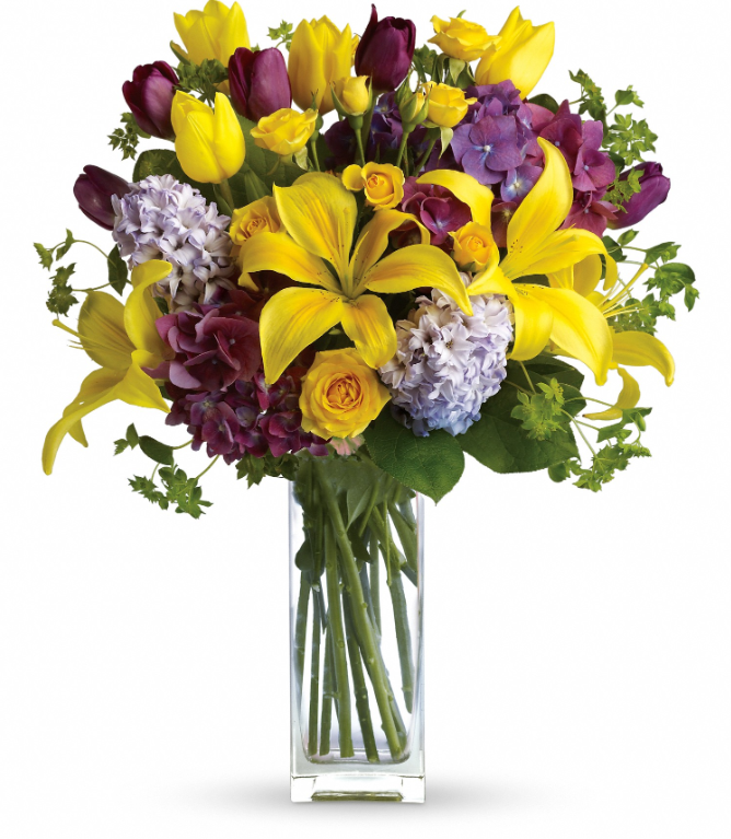 Bright yellow and purple tulips with lush hyacinths in a glass vase, perfect for free delivery in Florida areas.