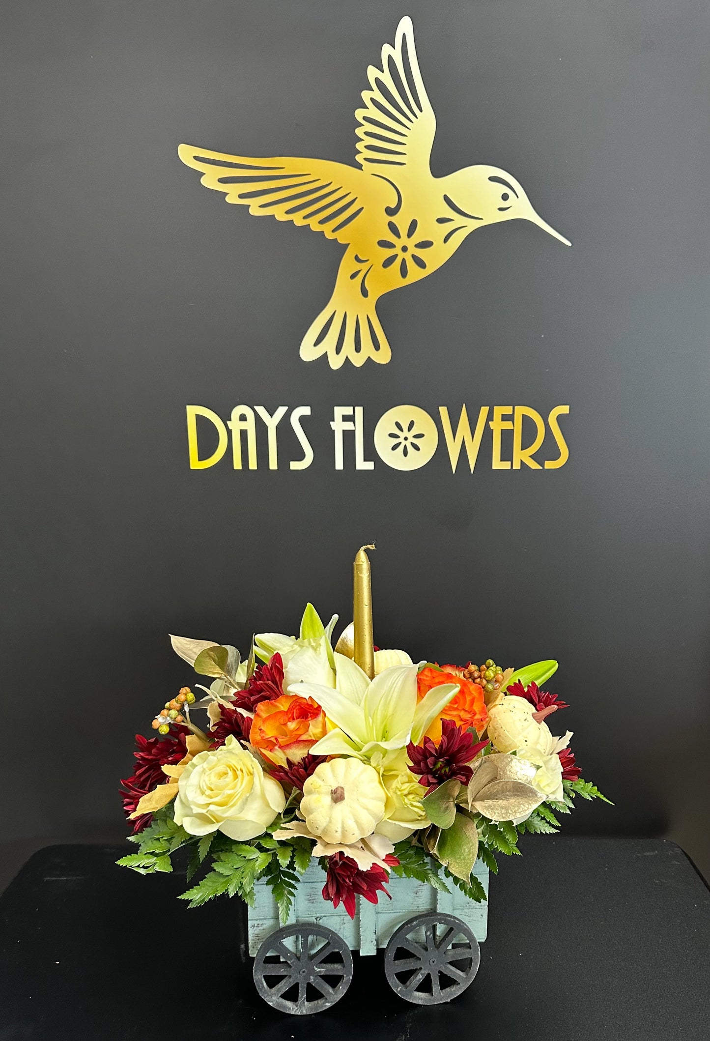Days Flowers Florida: Charming Thanksgiving wagon centerpiece featuring delicate pumpkin and autumn colors. Elegant holiday decor delivery in Ocala, Florida