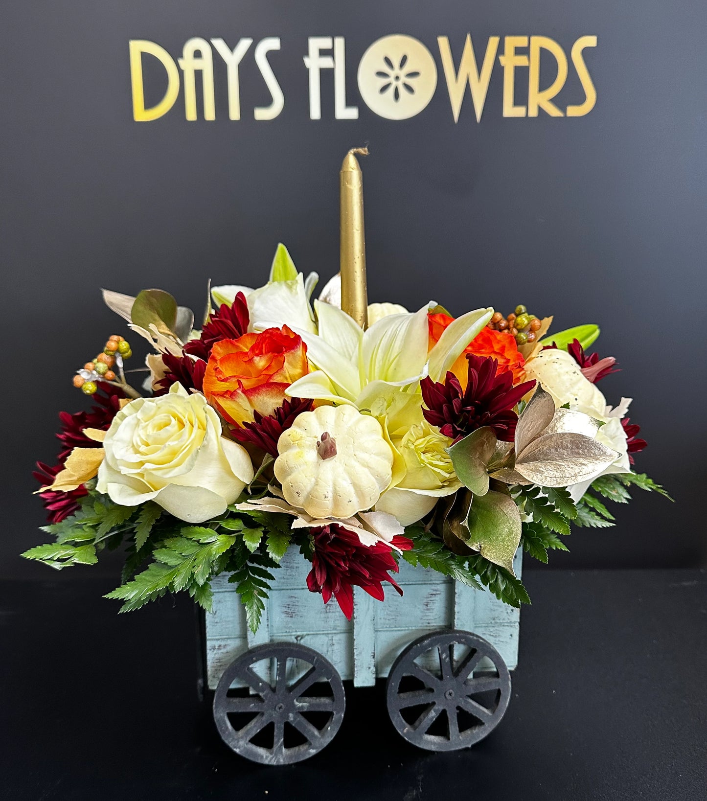 Days Flowers Florida: Autumn Harvest floral wagon. Vibrant Thanksgiving arrangement with golden candle. Festive decor gift delivery in Port St. Lucie.