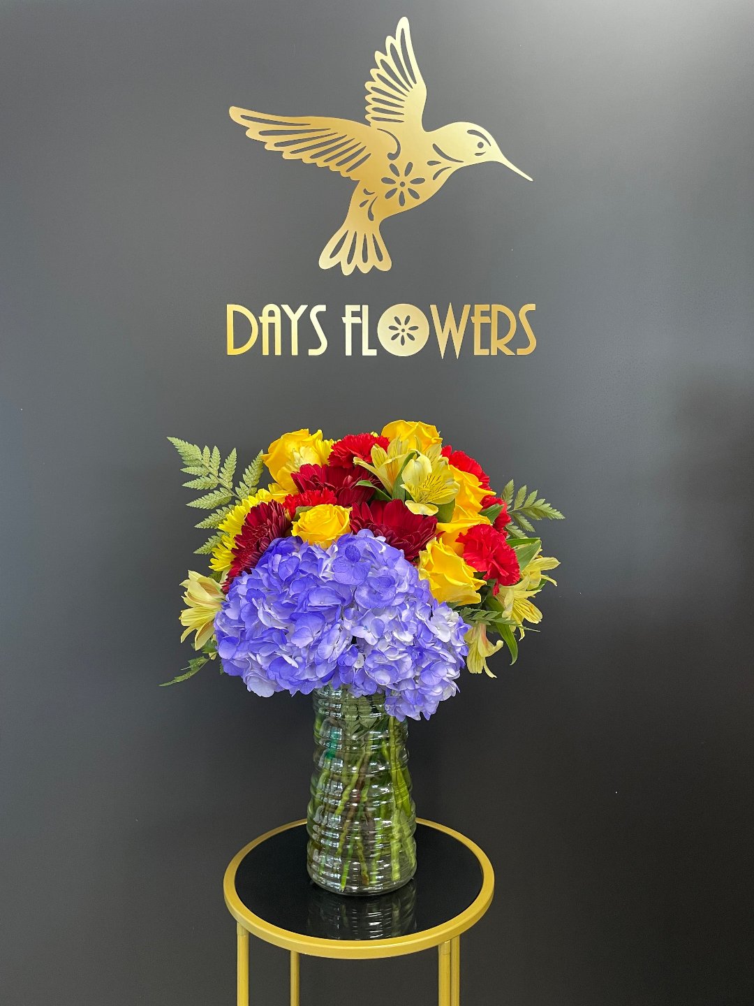 Vibrant flower bouquet in a vase with Days Flowers logo