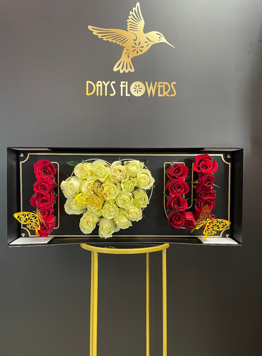 Deep Love Arrangement premium flower display by Days Flowers Florida, showcasing 30 fresh red and white roses decorated with delicate golden butterflies inside a luxury black gift box.