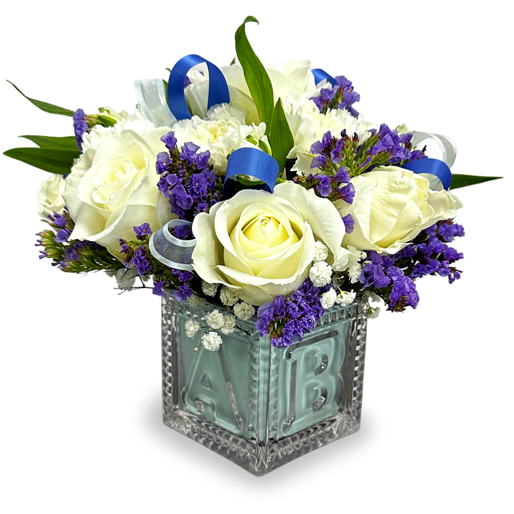 Little Lavender Love baby flower arrangement featuring white roses and purple statice inside a glass baby block vase by Days Flowers Florida.