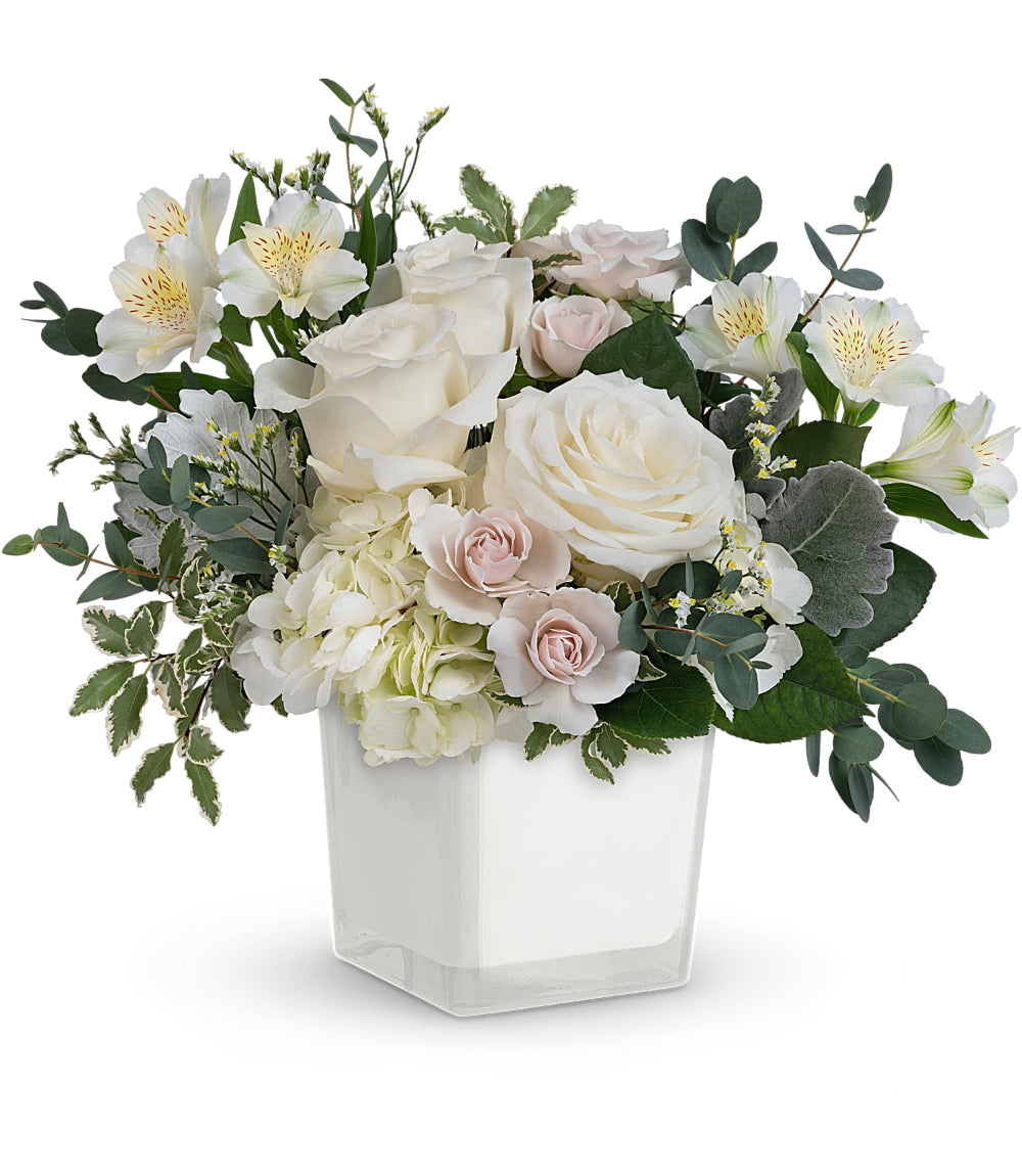 Peaceful Clouds Bouquet by Days Flowers Florida featuring white hydrangea, white roses, spray roses, white alstroemeria, limonium, eucalyptus, and greenery in a clear glass cube for an elegant and peaceful floral arrangement.
