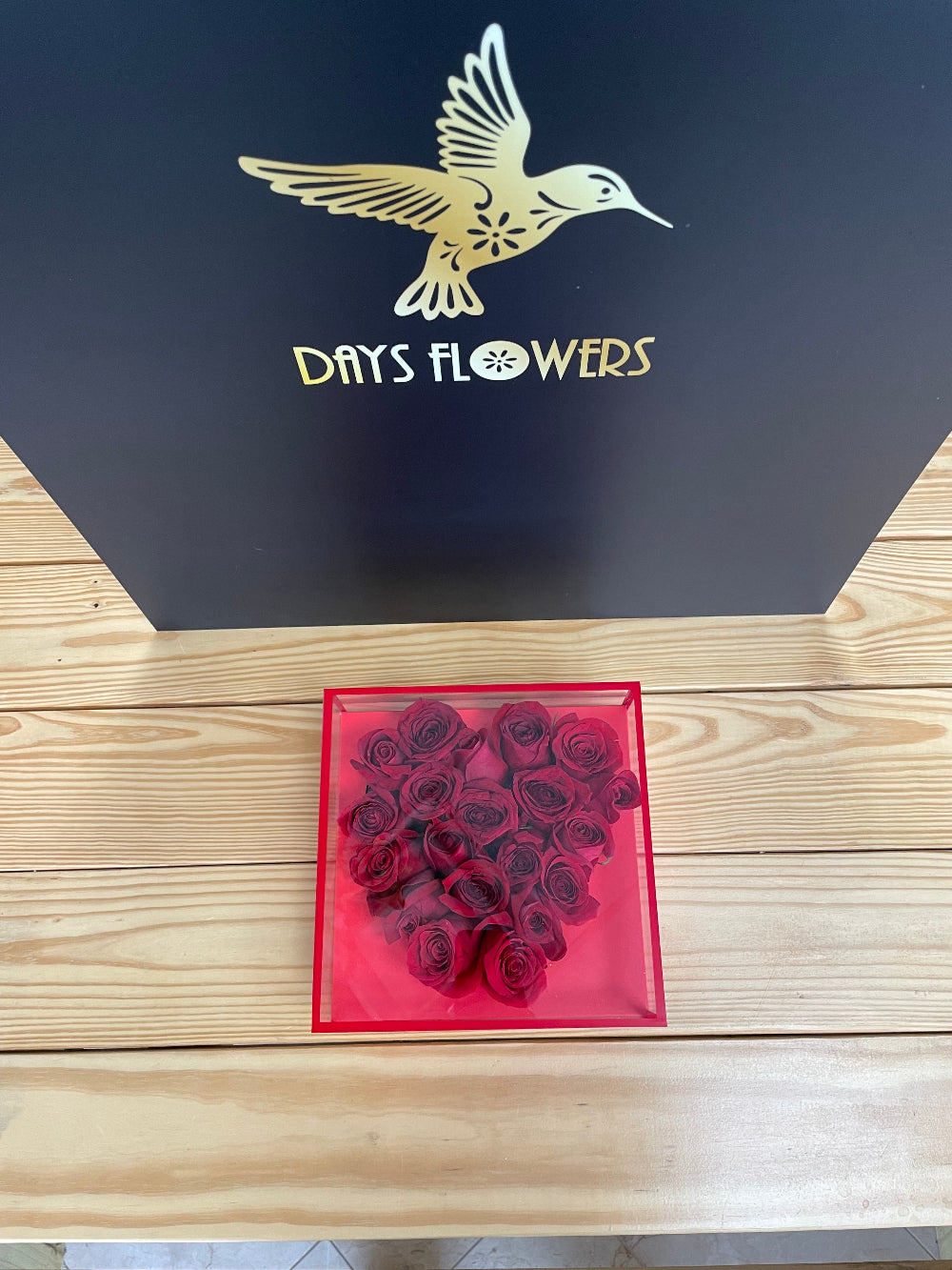 A beautiful top-down perspective of the Radiant Romance Collection from Days Flowers Florida, highlighting the neat, geometric symmetry of premium red roses in an upscale hatbox container.