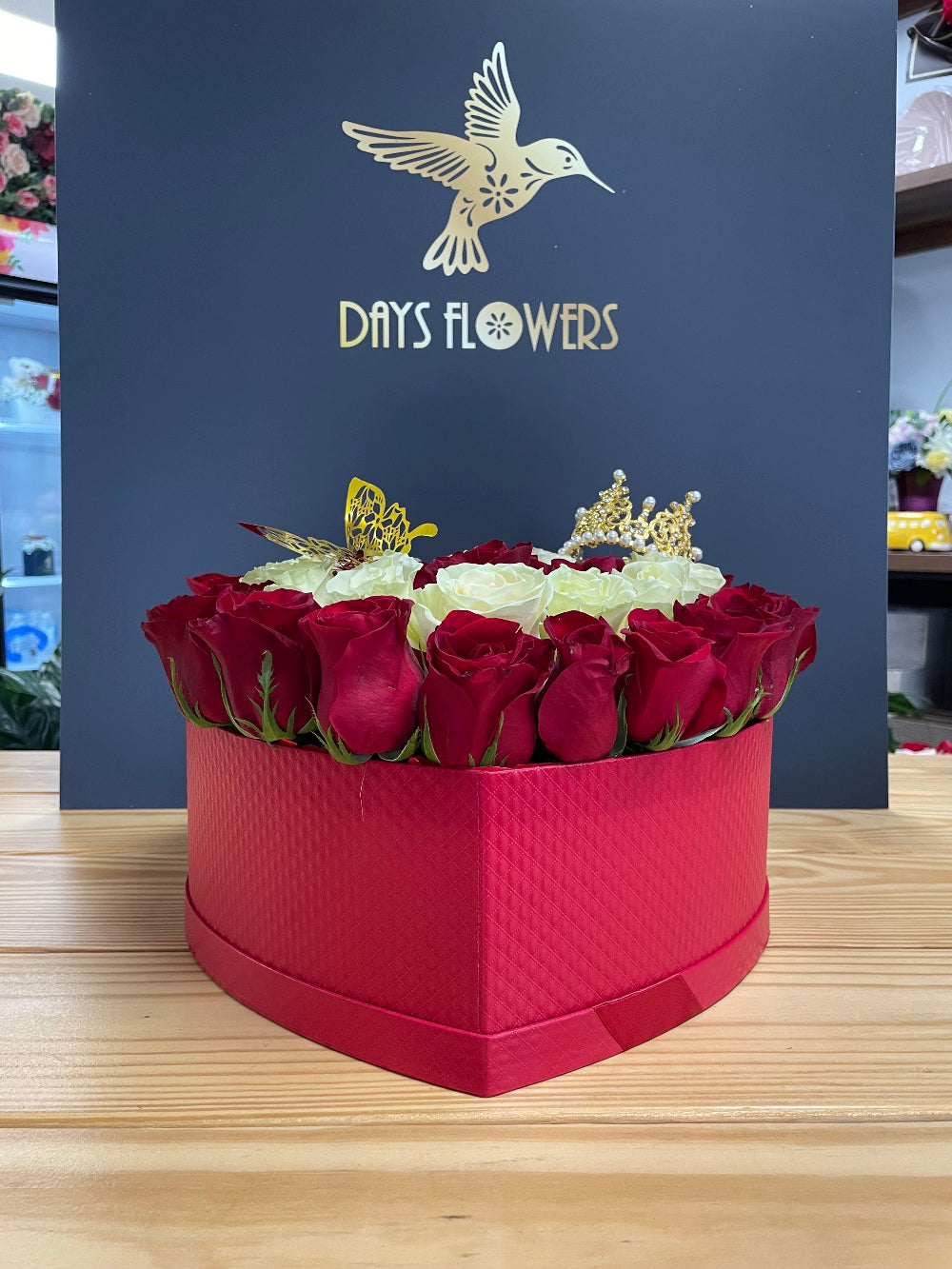 Premium holiday presentation of the Royal Bloom Crown design from Days Flowers Florida, showcasing the elegant circular gift box filled with fine quality red and white blossoms.