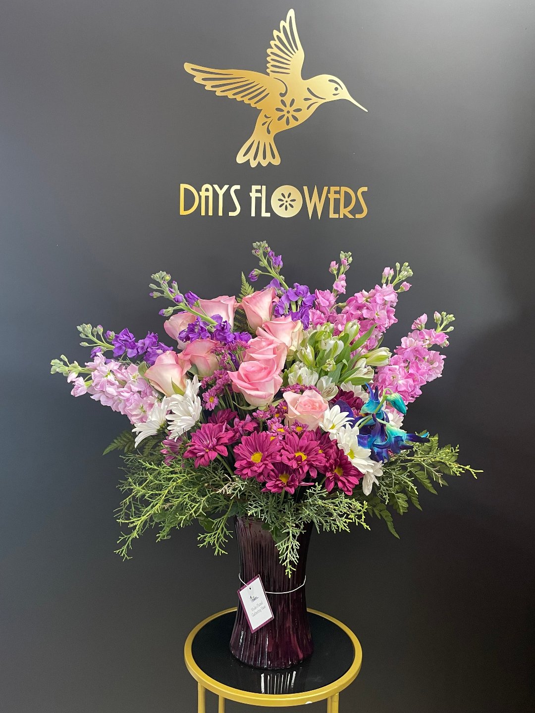 Grand scale floral presentation of Steal the Show by Days Flowers Florida, combining lavender cushions, purple statice, and salal foliage for unmatched height and premium texture.