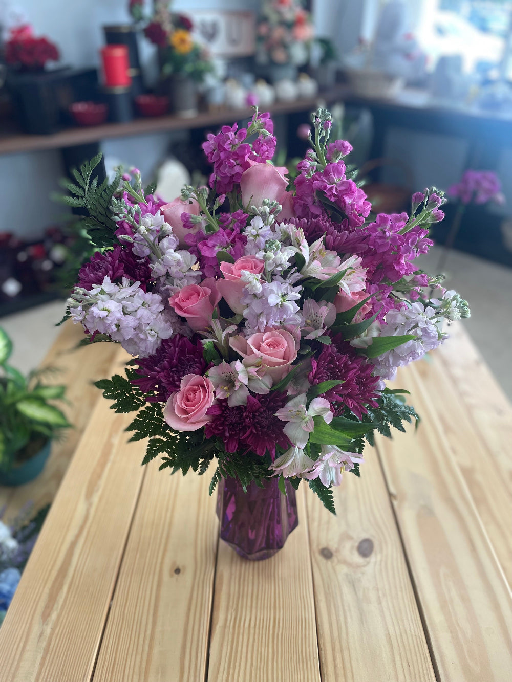 Close-up view of the Steal the Show arrangement from Days Flowers Florida, capturing the intricate details of lavender freesia petals and purple matsumoto asters mixed with seeded eucalyptus.