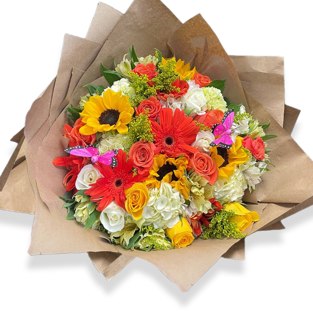 Sunny Days Bouquet by Days Flowers Florida, displaying an abundant hand-wrapped medley of golden yellow sunflowers, passionate red roses, and pink blossoms nestled in rustic brown paper.