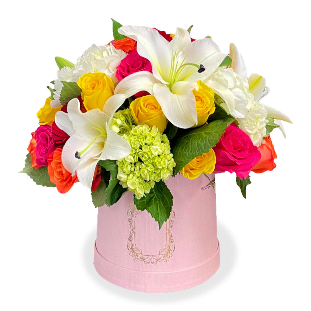 Sunshine Serenade floral arrangement by Days Flowers Florida, displaying an upscale mix of white lilies, yellow roses, pink roses, and green hydrangeas nested inside a premium pink hatbox container.