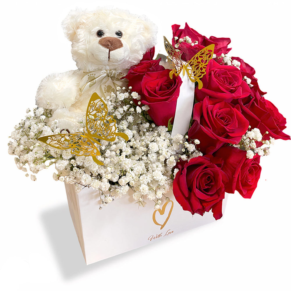 Teddy Love Box by Days Flowers Florida, featuring a premium arrangement of twelve classic red roses and a soft plush teddy bear tucked inside a romantic white gift box with gold hearts.