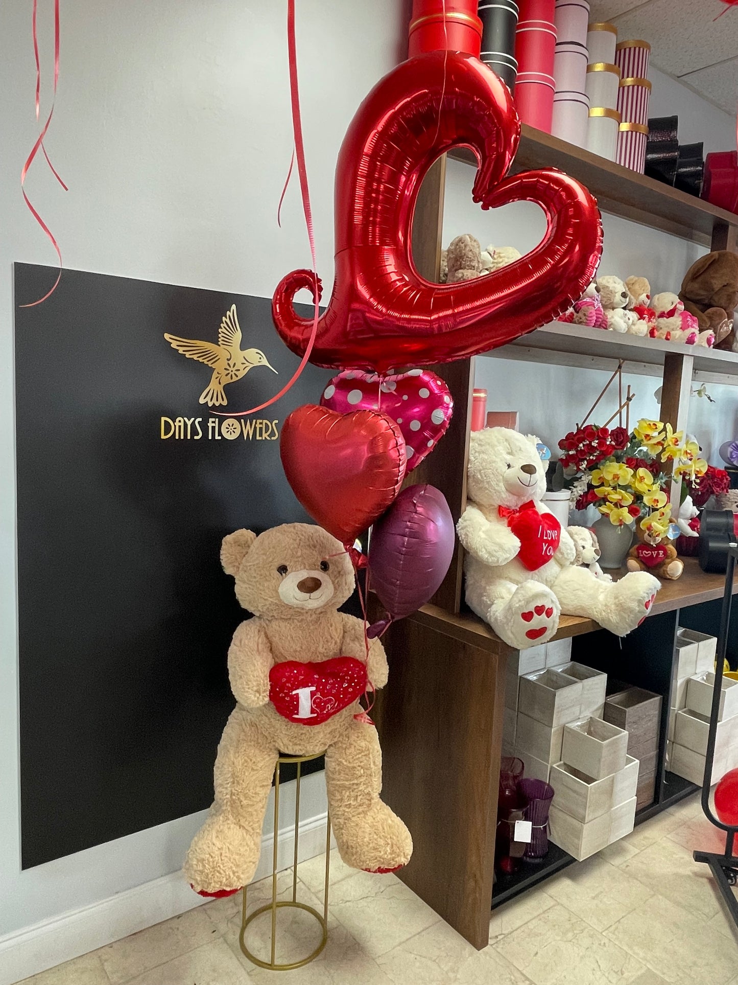Days Flowers Florida: Teddy bear and heart cushion arrangement with balloons. Epitome of love and warmth gift delivery in Summerfield, Florida.