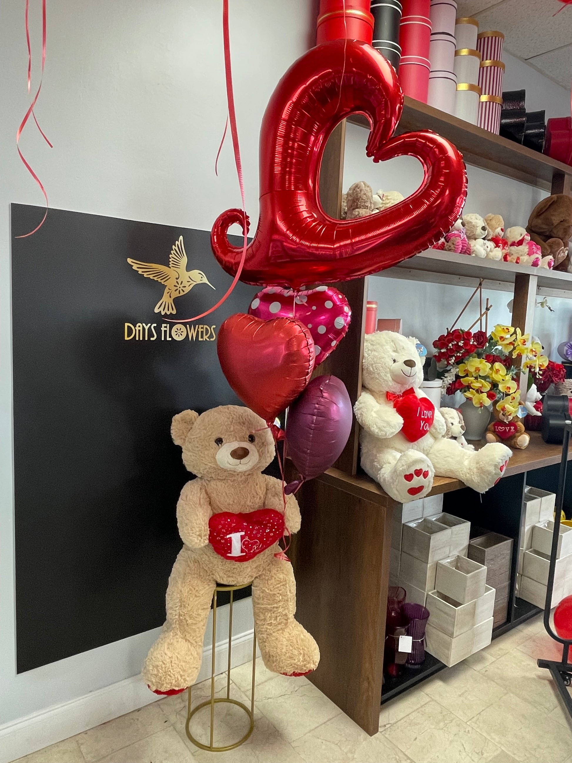 Days Flowers Florida: Teddy bear and heart cushion arrangement with balloons. Epitome of love and warmth gift delivery in Summerfield, Florida.