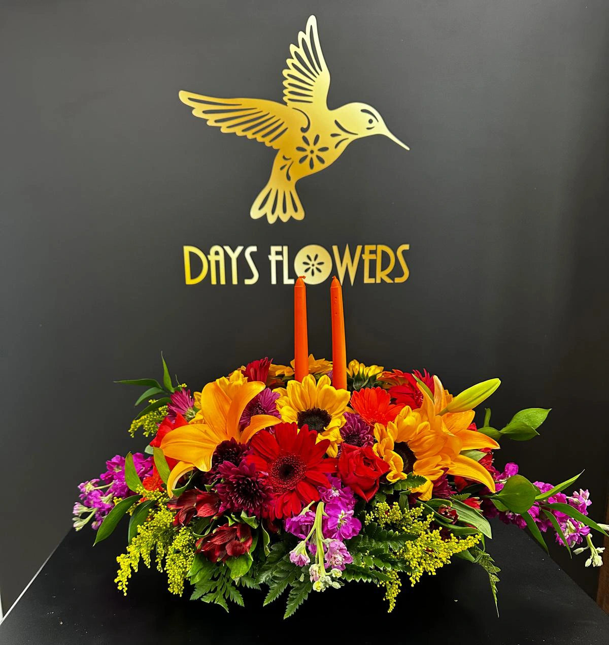 Days Flowers Florida: Stunning Thanksgiving arrangement featuring lilies, gerberas, and warm red/orange shades. Festive centerpiece delivery in Summerfield, Florida