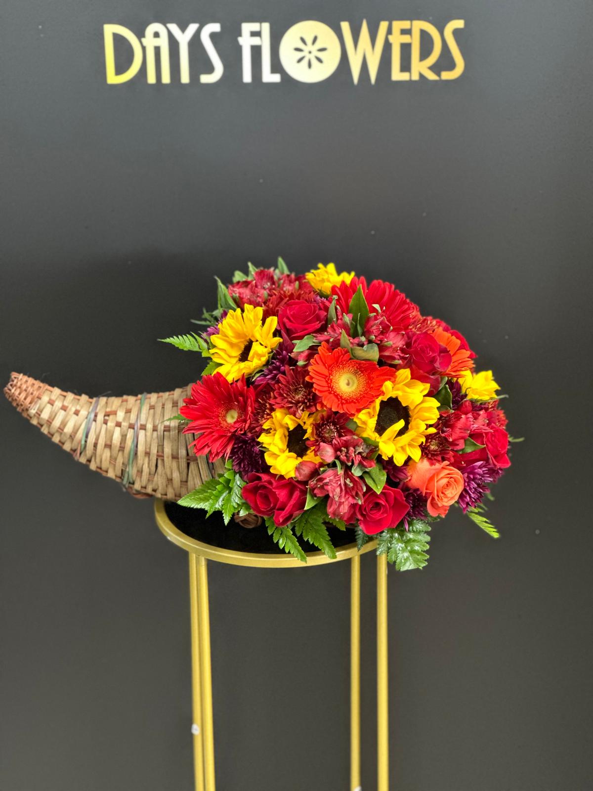 Days Flowers Florida: Stunning cornucopia floral arrangement with red, orange, and yellow hues. Festive Thanksgiving decor delivery in Port St. Lucie.