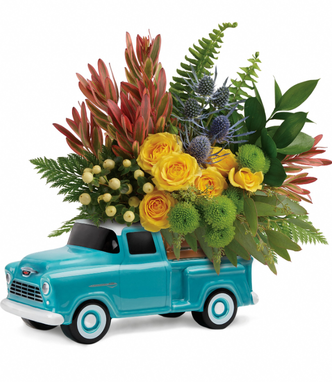 Timeless Chevy Pickup floral design by Days Flowers Florida, featuring a bright bouquet of yellow roses, hypericum berries, and rich green ferns emerging from the truck bed of a collectible blue ceramic Chevrolet pickup container.