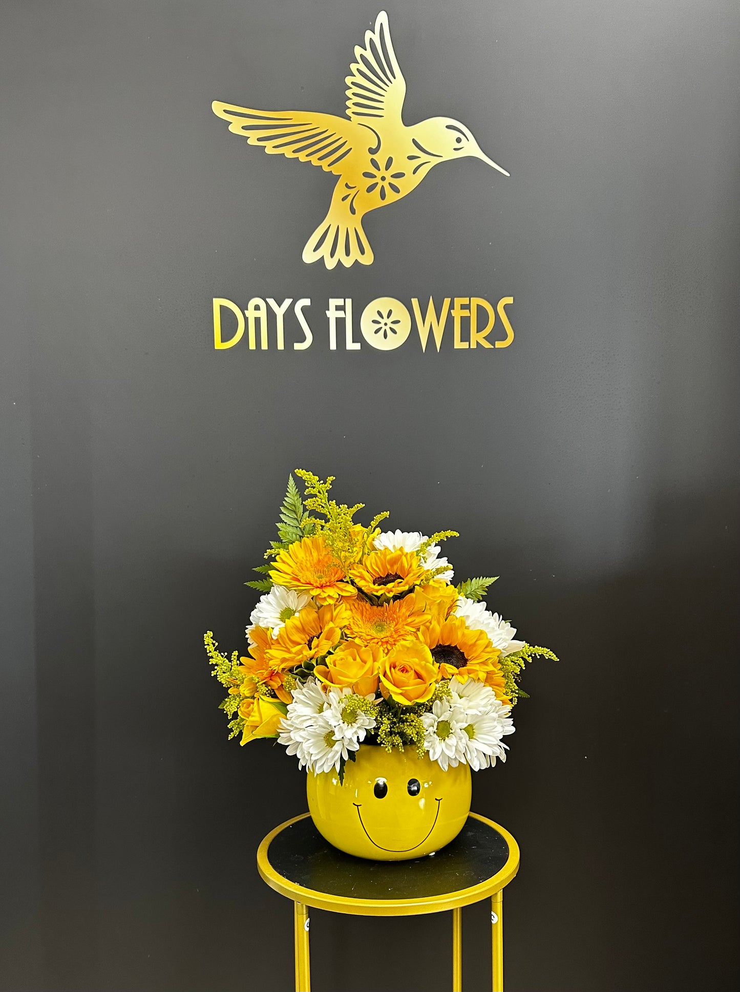 Days Flowers Florida: Vibrant orange and yellow blooms in a smiley-face container. Perfect for spreading happiness and celebration in Port St. Lucie.
