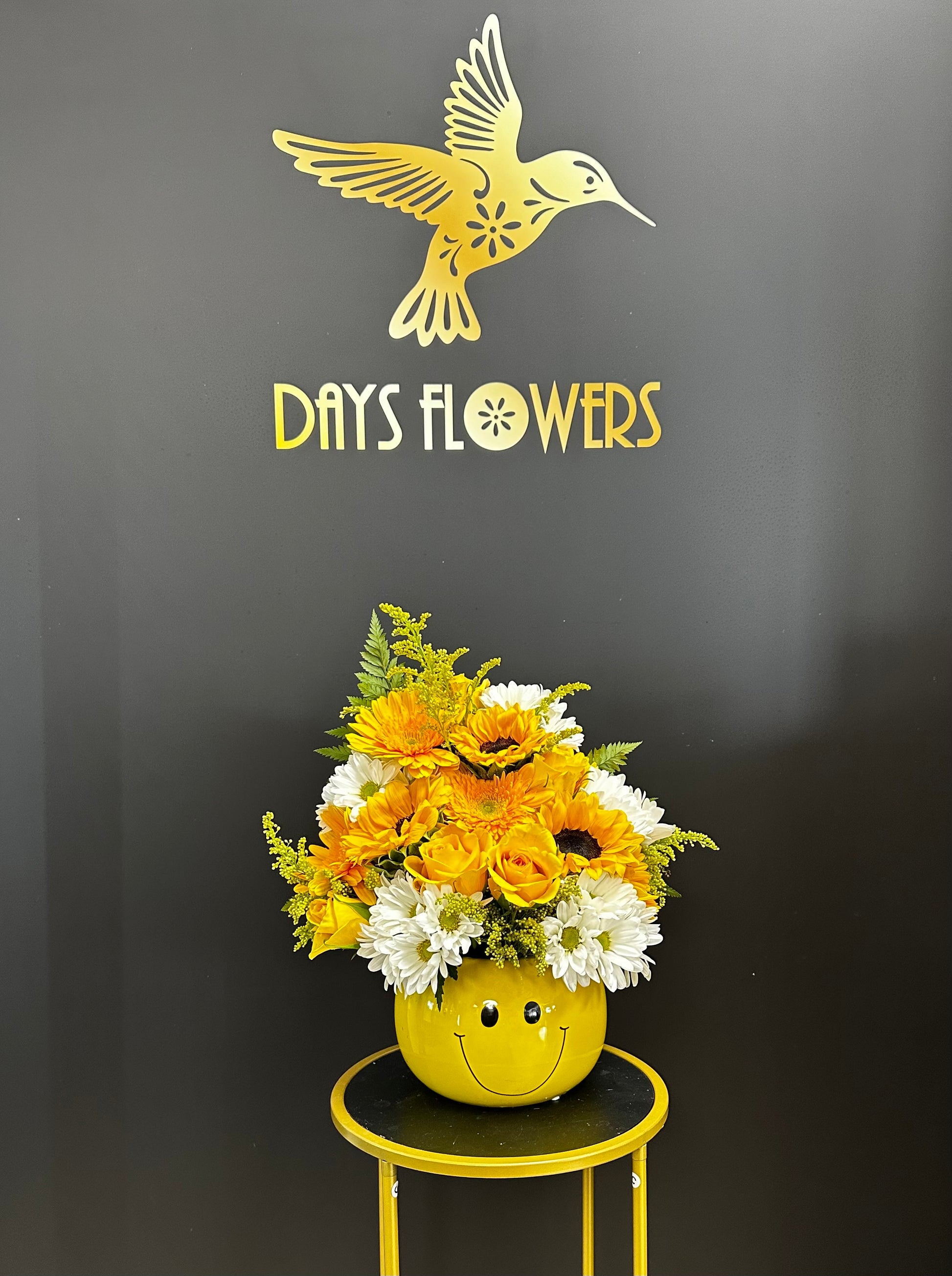 Days Flowers Florida: Vibrant orange and yellow blooms in a smiley-face container. Perfect for spreading happiness and celebration in Port St. Lucie.