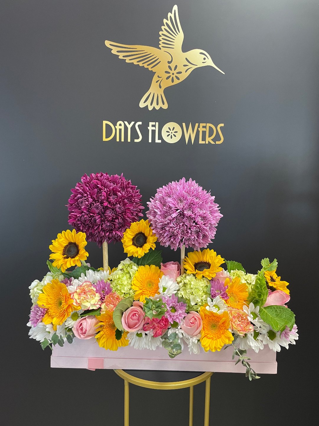 Close-up of the stylish rectangular pink box displaying soft pink roses and deep purple chrysanthemums