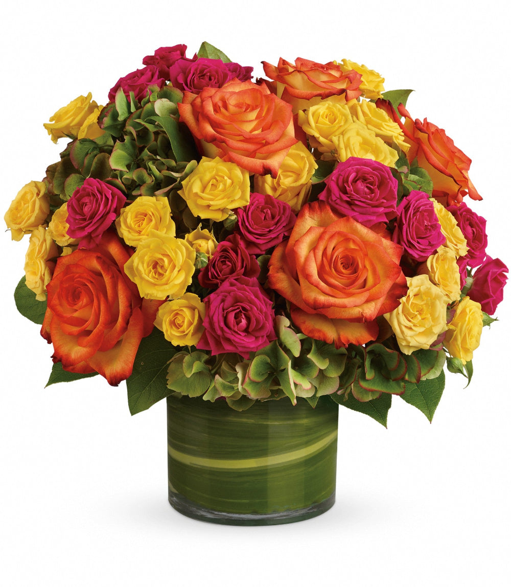Close-up of the 5-inch clear glass cylinder vase showcasing folded variegated aspidistra leaves and fresh rose stems
