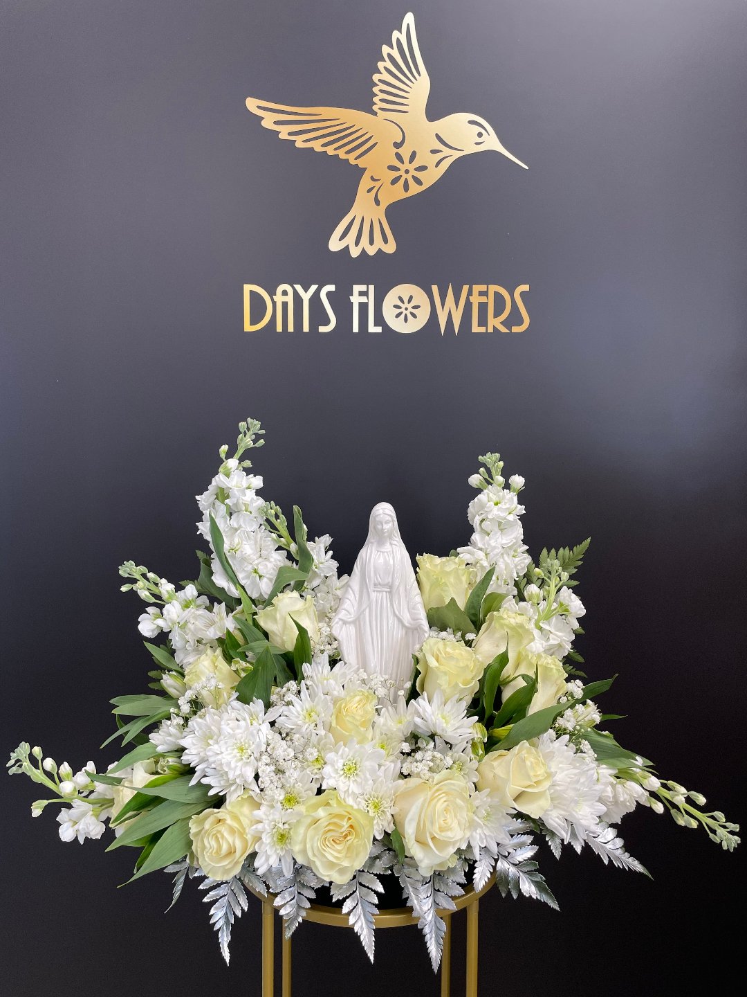 Elegant white and yellow flowers with statue centerpiece, perfect for gifting in Florida