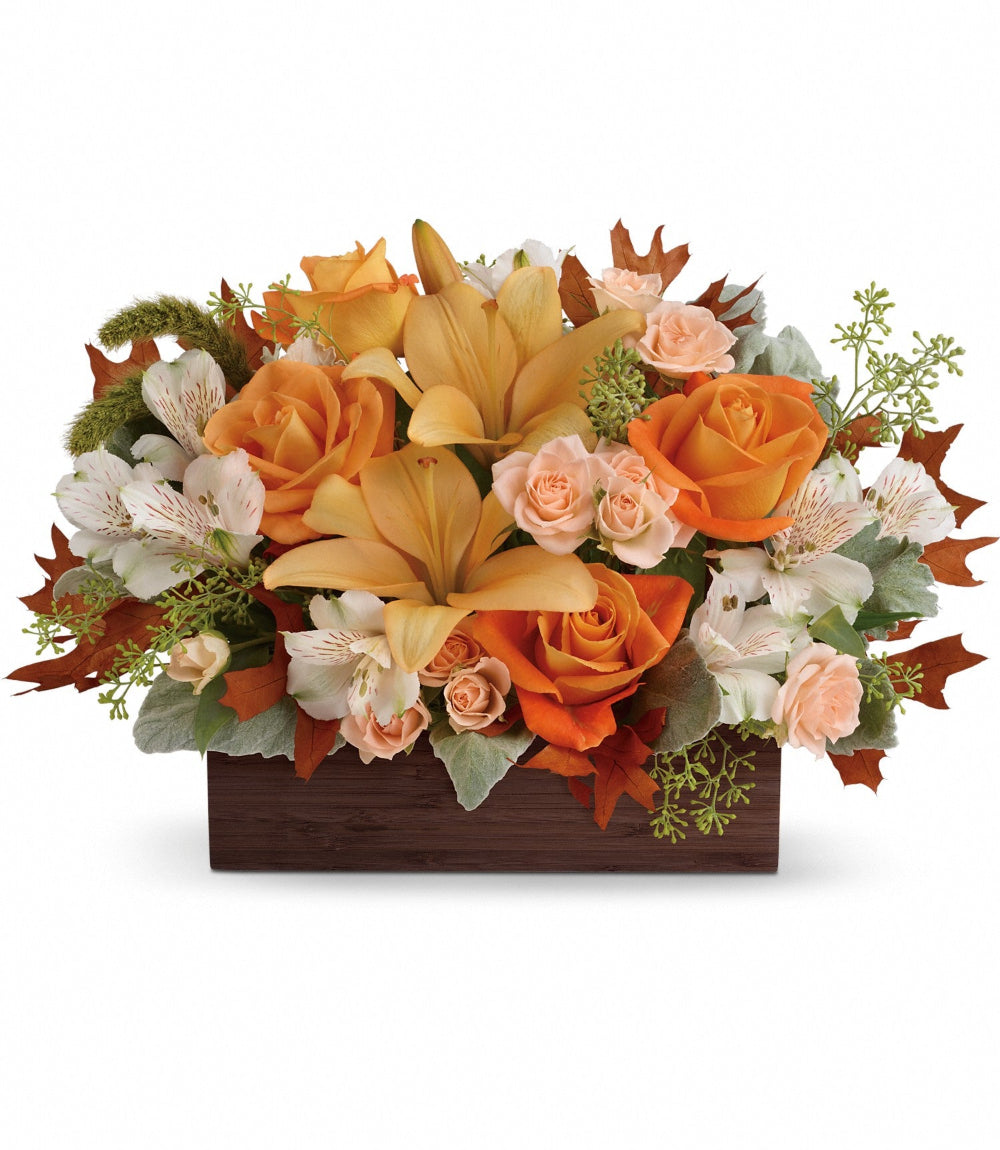 Fall Chic Bouquet featuring light orange roses, peach asiatic lilies, and white alstroemeria in a dark brown bamboo planter by Days Flowers Florida.