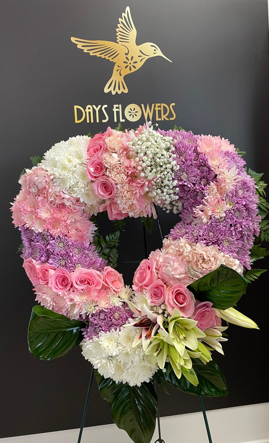 Elegant floral wreath with pink roses and white lilies, available for free delivery in Florida areas.