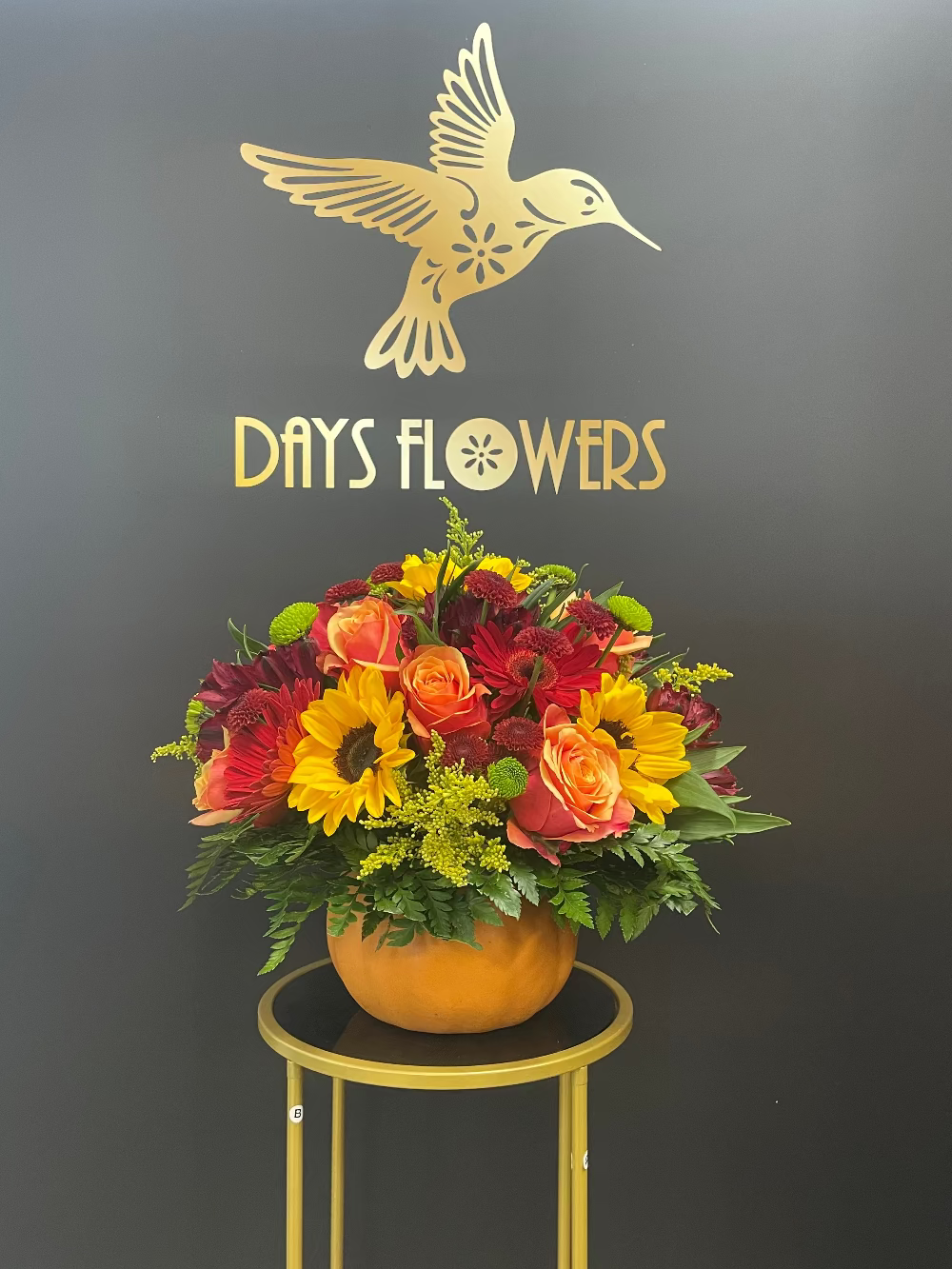 Close-up of rich pumpkin-orange blossoms paired with dark dramatic foliage elements.
