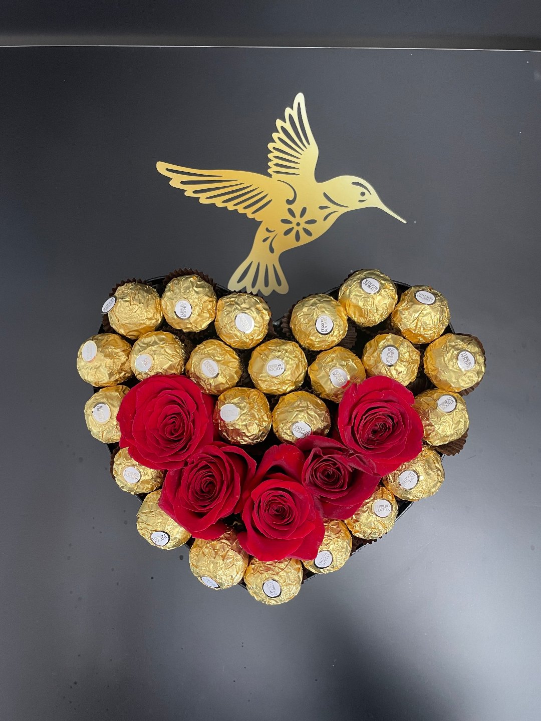 Heart-shaped bouquet with red roses and gold chocolates, delivery in Florida.