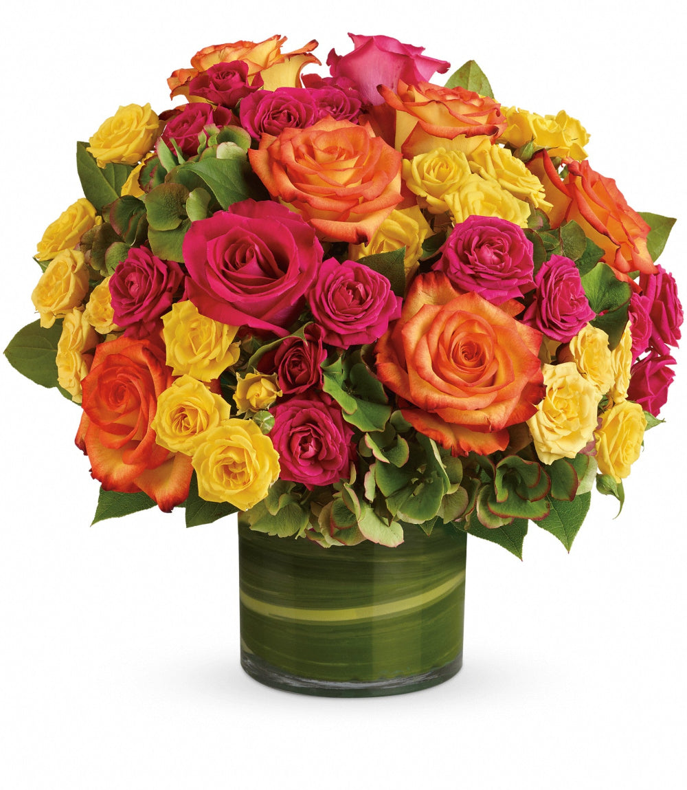 Top-down perspective of the Blossoms in Vogue arrangement showing the dense placement of orange bi-color roses and yellow spray roses