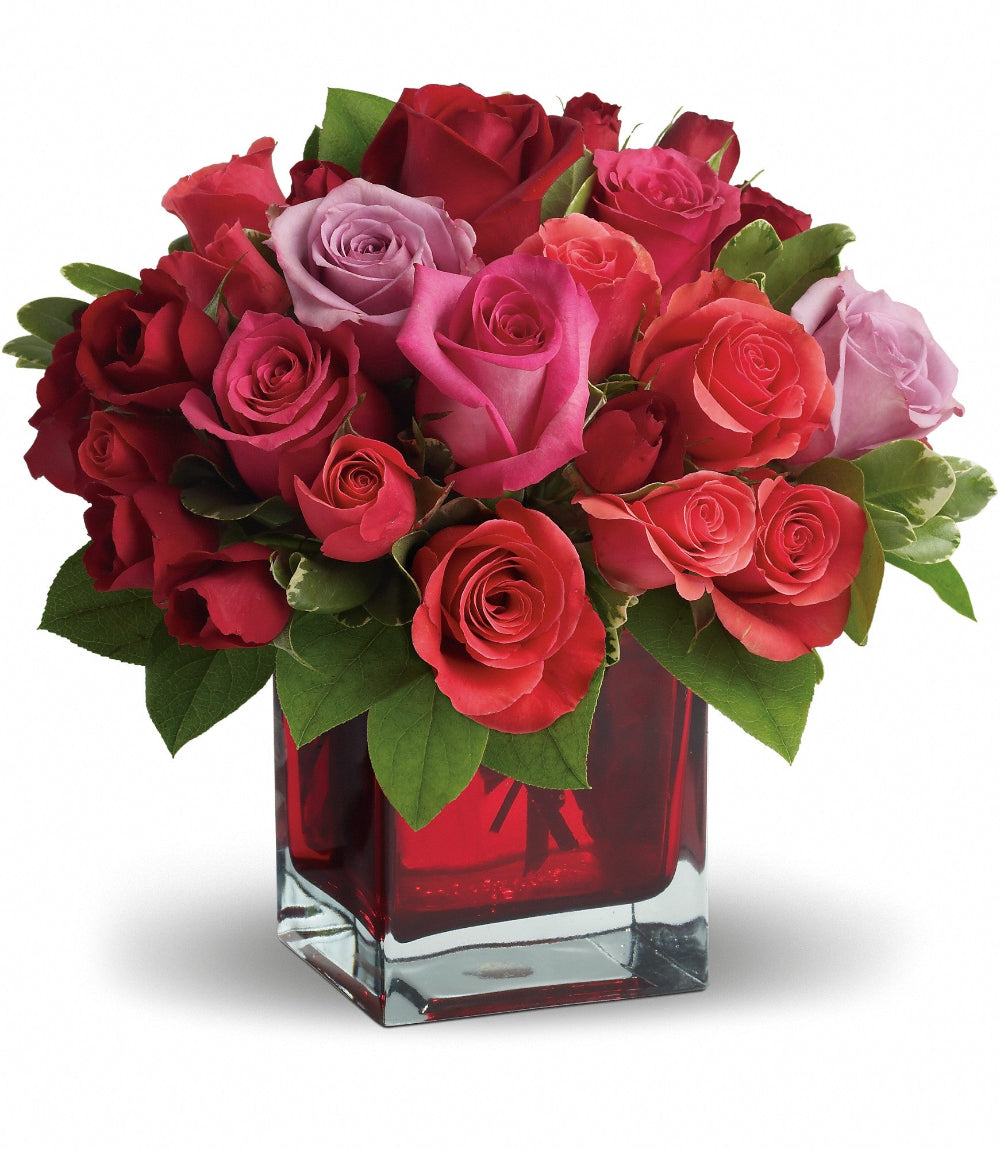 Madly in Love Bouquet featuring red, hot pink, lavender, and coral roses in a red glass cube vase by Days Flowers Florida