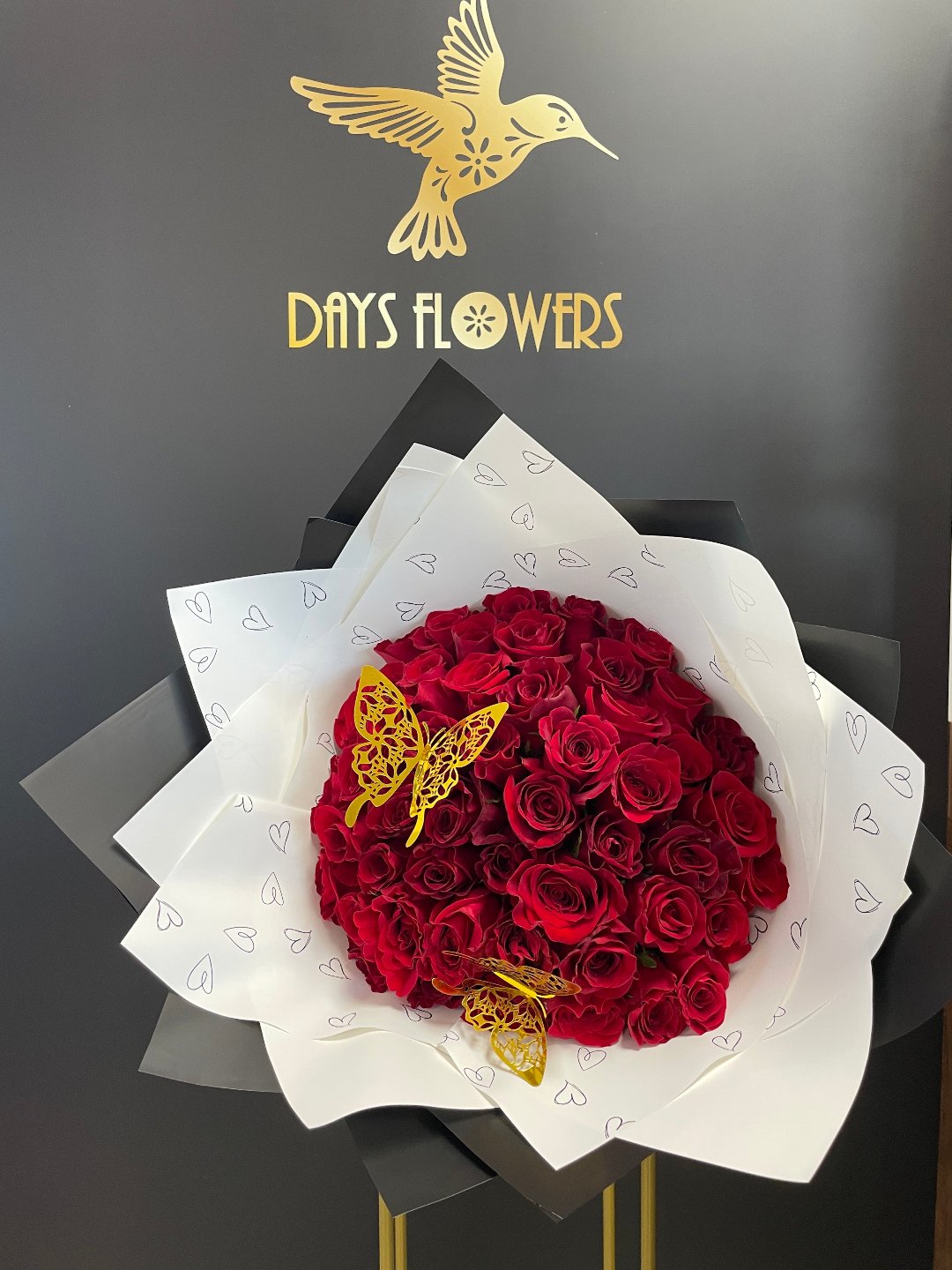 Elegant red rose bouquet with butterfly accents from Days Flowers, available for free delivery in Florida areas.