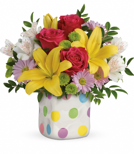 Colorful bouquet with red roses, yellow lilies, and pink daisies in a polka-dotted vase, perfect for delivery in Summerfield, Ocala, Orlando, The Villages, and Port St. Lucie.