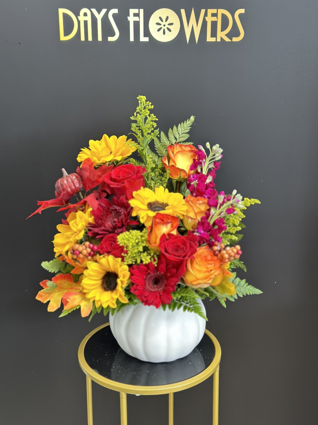 Top-down perspective of the Autumn Splendor Bouquet showing bright sunflowers paired with red roses and chrysanthemums