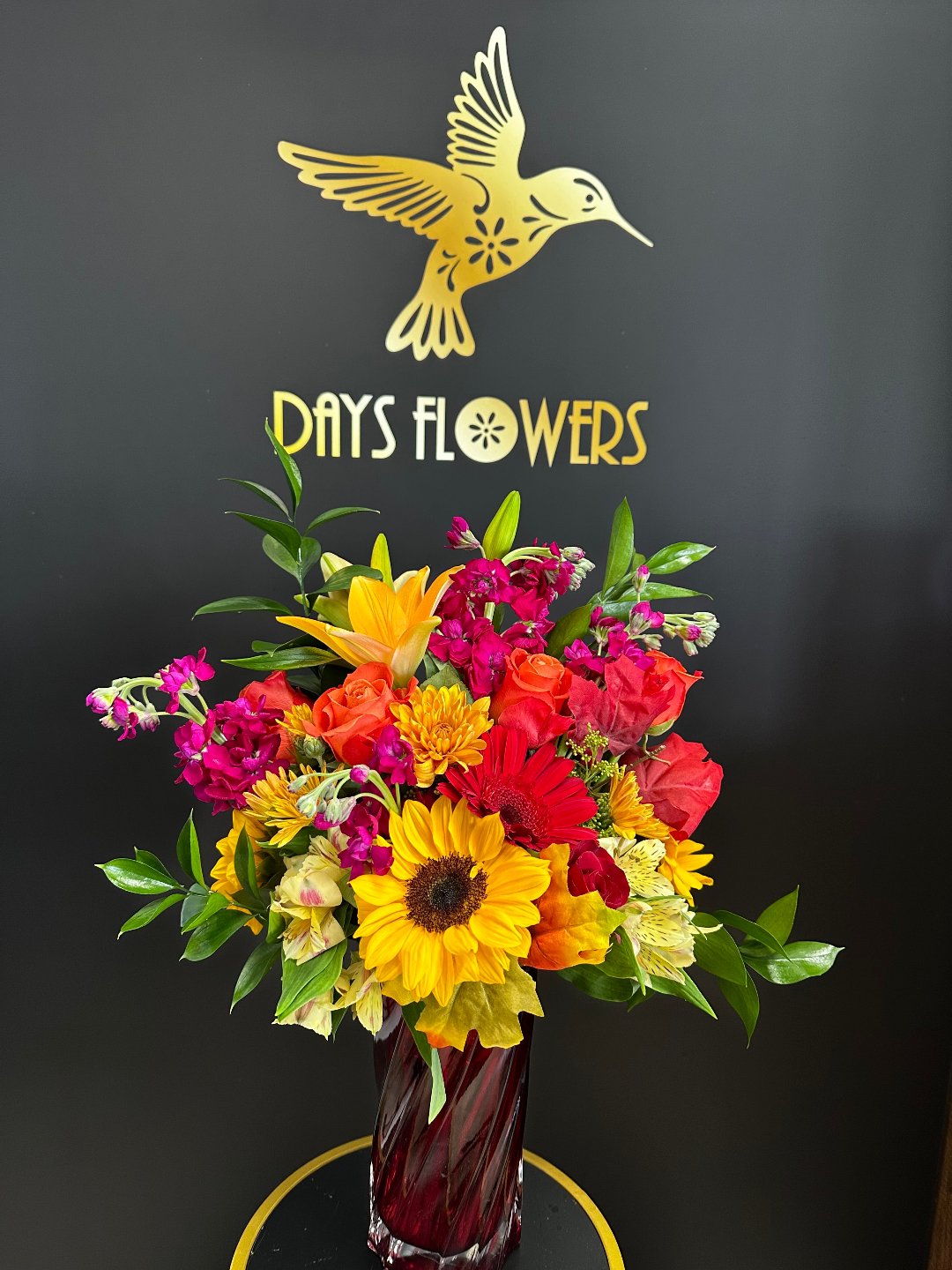 Vibrant bouquet of red, yellow, and pink flowers in a clear vase, perfect gift from Day’s Flowers in Florida.