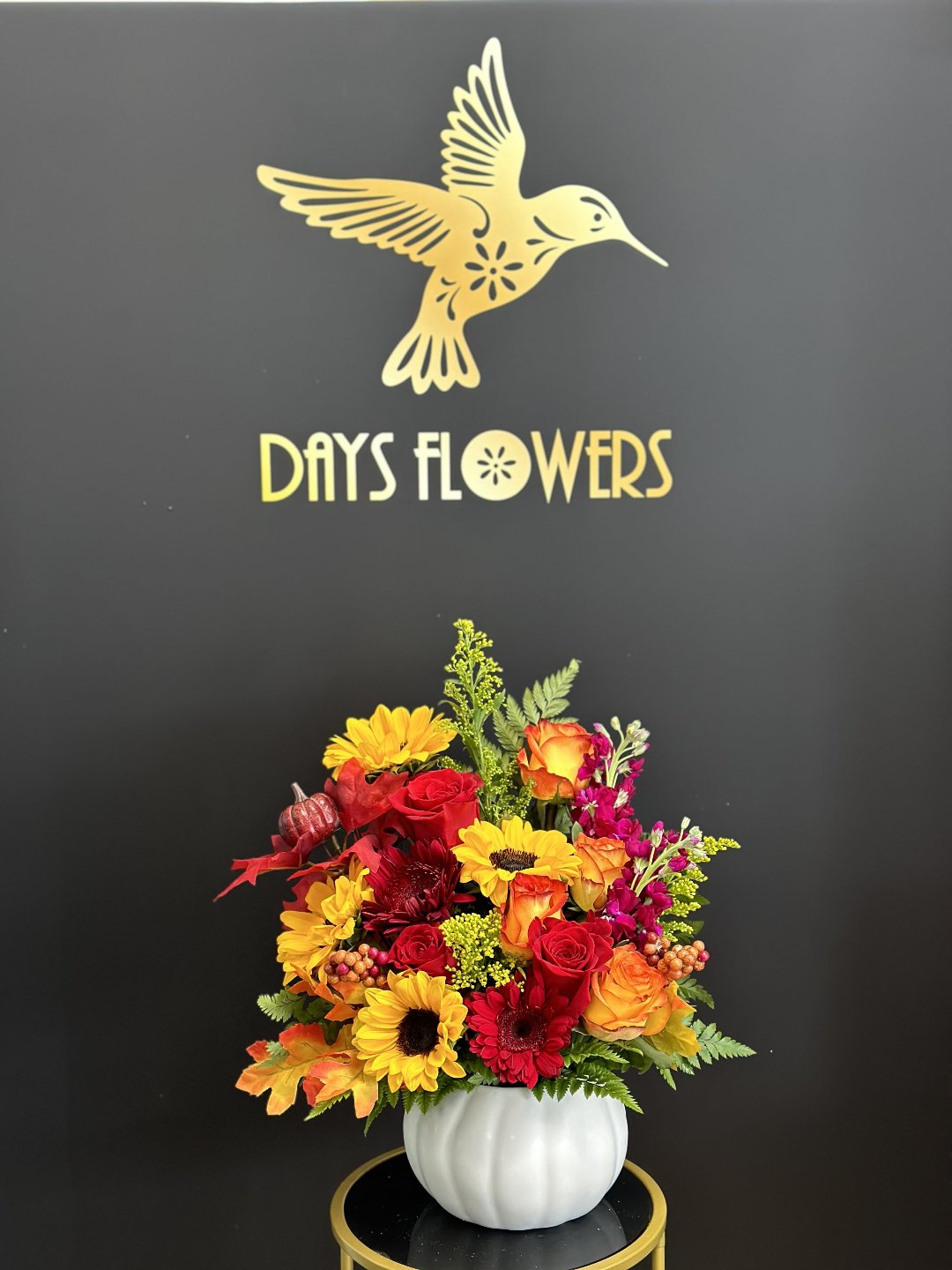 Vibrant bouquet with red, yellow, and orange flowers in a white vase, perfect gift for delivery in Florida.