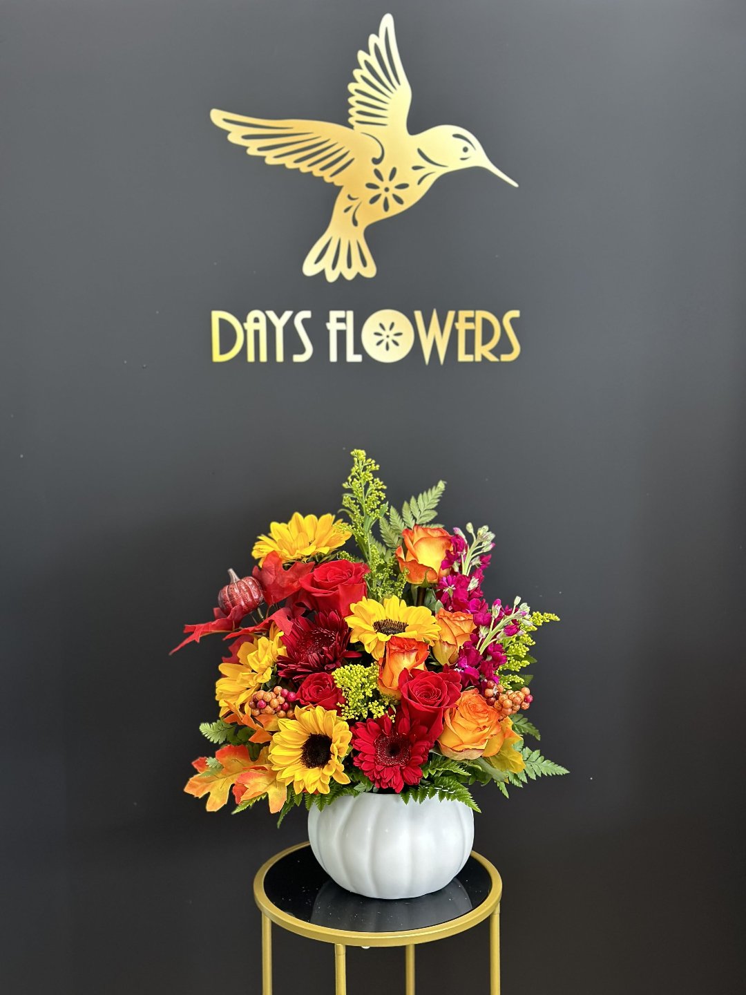 Bright floral arrangement with red, yellow, and orange blooms in a white vase, perfect gift from Day’s Flowers in Florida.