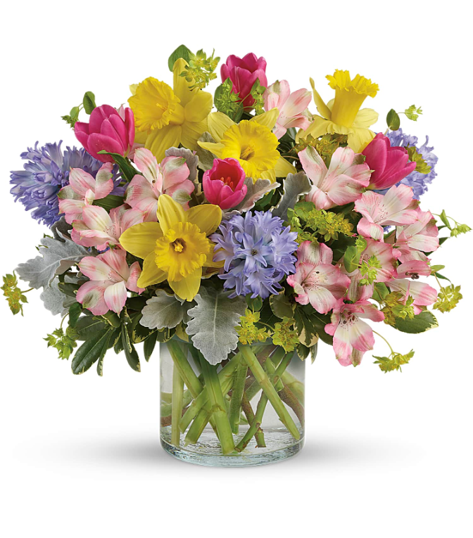 Vibrant spring bouquet with yellow daffodils, pink tulips, and purple hyacinths in a glass vase, perfect for free delivery in Florida areas.