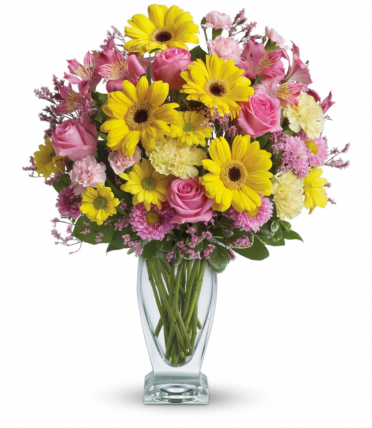 Close-up of the clear Teleflora Couture glass vase displaying fresh yellow gerberas and variegated pittosporum foliage
